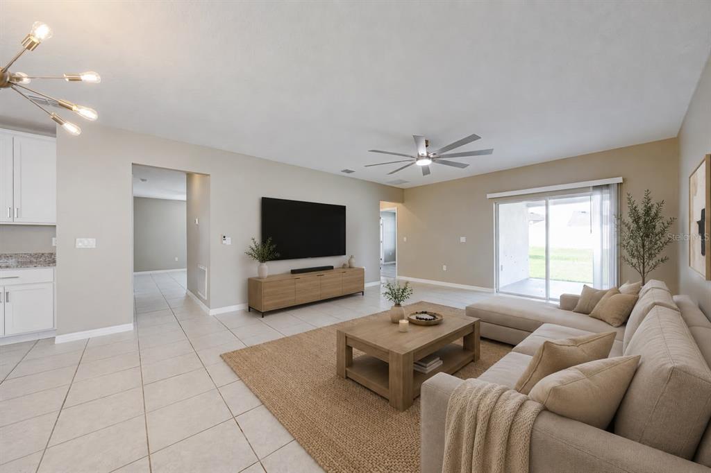 A living room features a beige sectional sofa, a wooden coffee table, and a wall-mounted television — 352 BRIARBROOK LANE, HAINES CITY, FL