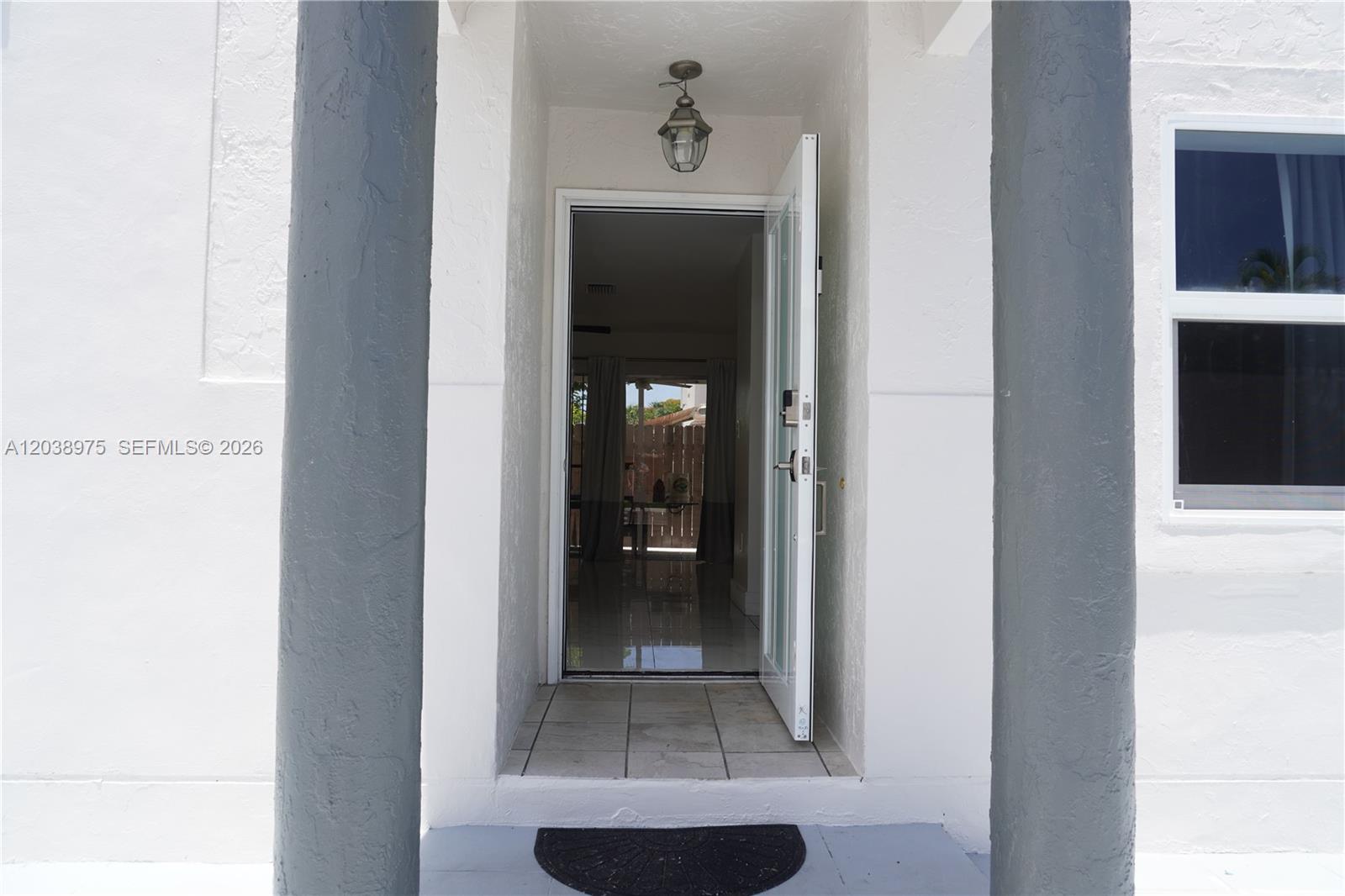 An open front door reveals a tiled entryway and a view through to the backyard — 9132 SW 148th Ct # 0, Miami FL 33196, MIAMI, FL
