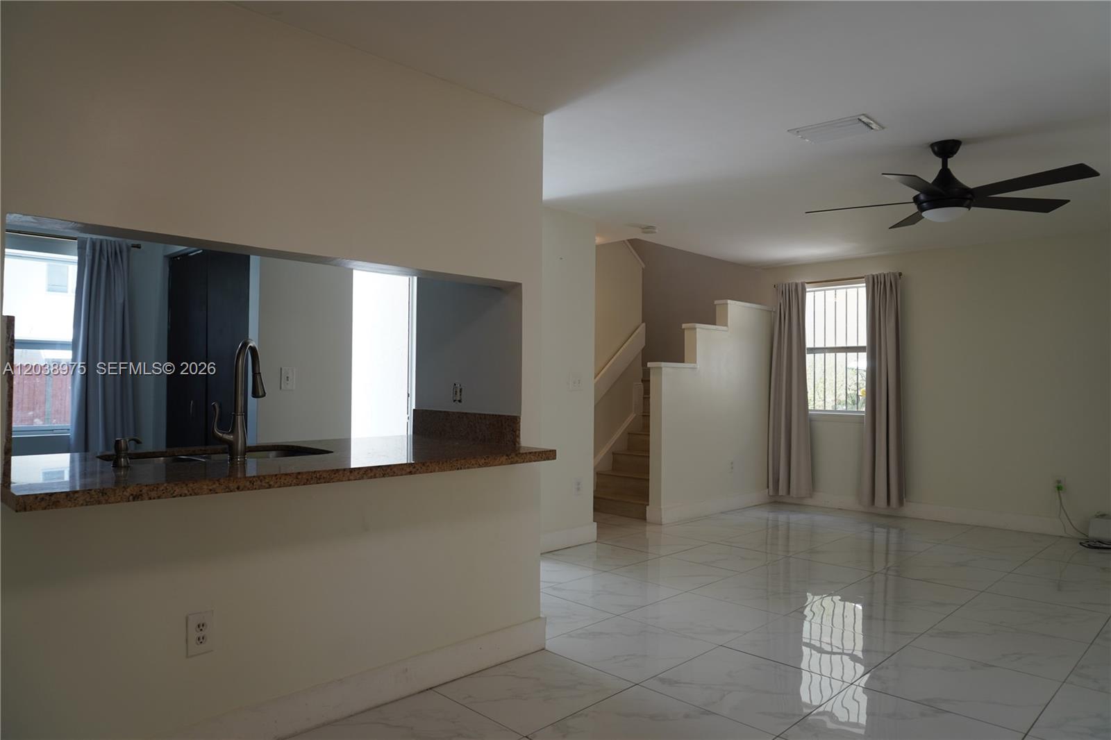 A kitchen pass-through overlooks a living area with white tile floors and a staircase — 9132 SW 148th Ct # 0, Miami FL 33196, MIAMI, FL