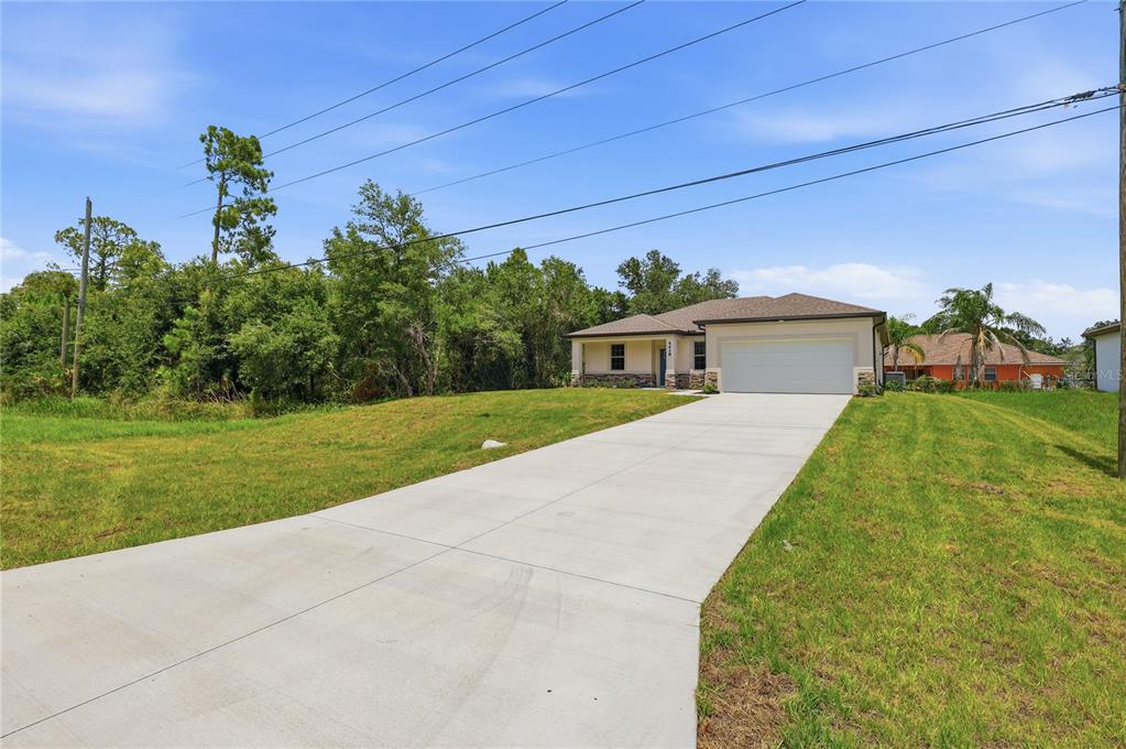 A single-story house with a white garage and a concrete driveway sits on a lawn — 4418 PONCE DE LEON BOULEVARD, NORTH PORT, FL