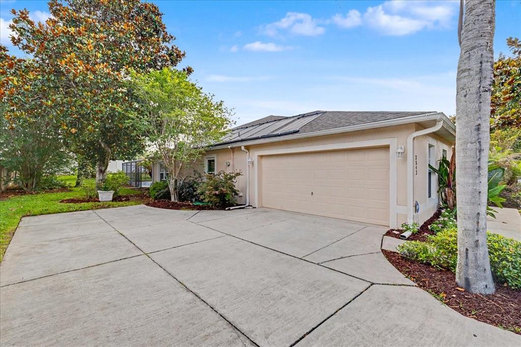 A beige house with a two-car garage and a concrete driveway under a blue sky — 2543 PALMETTO RIDGE CIRCLE, APOPKA, FL