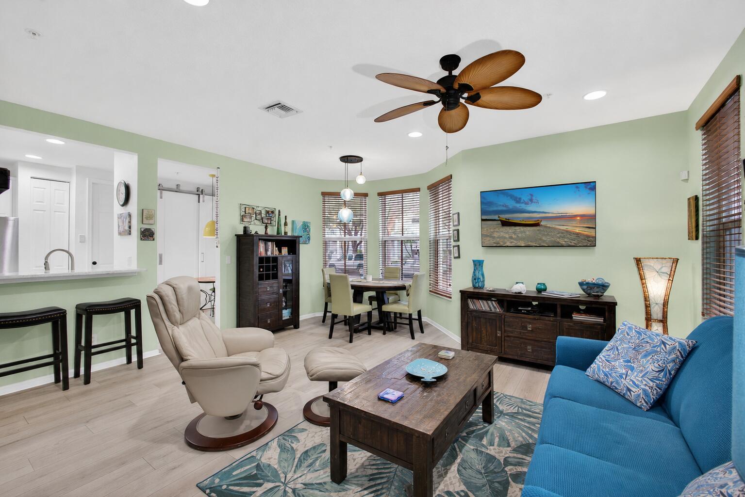 A living room with light green walls, a blue sofa, and a wooden coffee table — 4345 Parkside Drive, Jupiter FL 33458, JUPITER, FL
