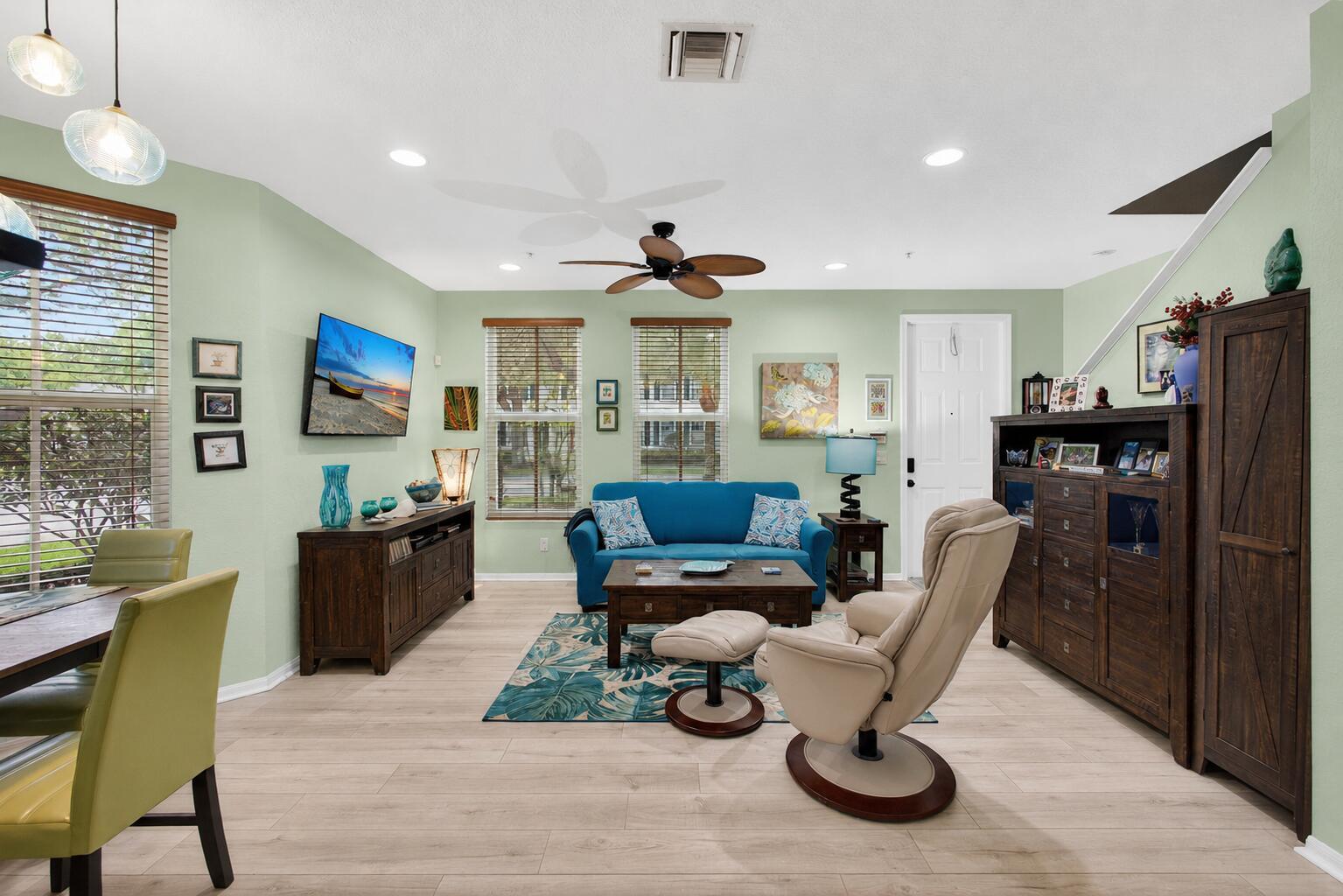 A living room features light green walls, a blue sofa, a beige recliner, and wood furniture — 4345 Parkside Drive, Jupiter FL 33458, JUPITER, FL