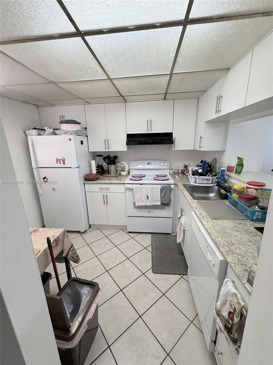 A kitchen features white cabinets, white appliances, a tiled floor, and a drop ceiling — 19715 SW 114th Ave # 258, Miami FL 33157, MIAMI, FL