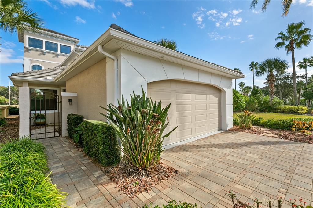 A paved driveway leads to a beige garage door and a gated side entrance — 259 YACHT HARBOR DRIVE, PALM COAST, FL
