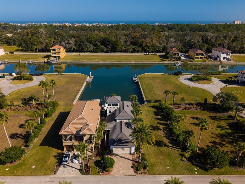 An aerial view shows a waterfront house with a boat slip and a private dock — 259 YACHT HARBOR DRIVE, PALM COAST, FL