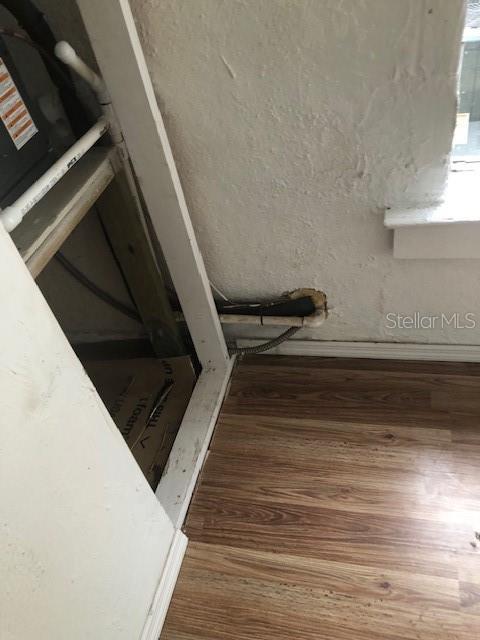 A view of a corner showing a utility area with exposed pipes and wood flooring — 414 NW 9TH AVENUE, OCALA, FL