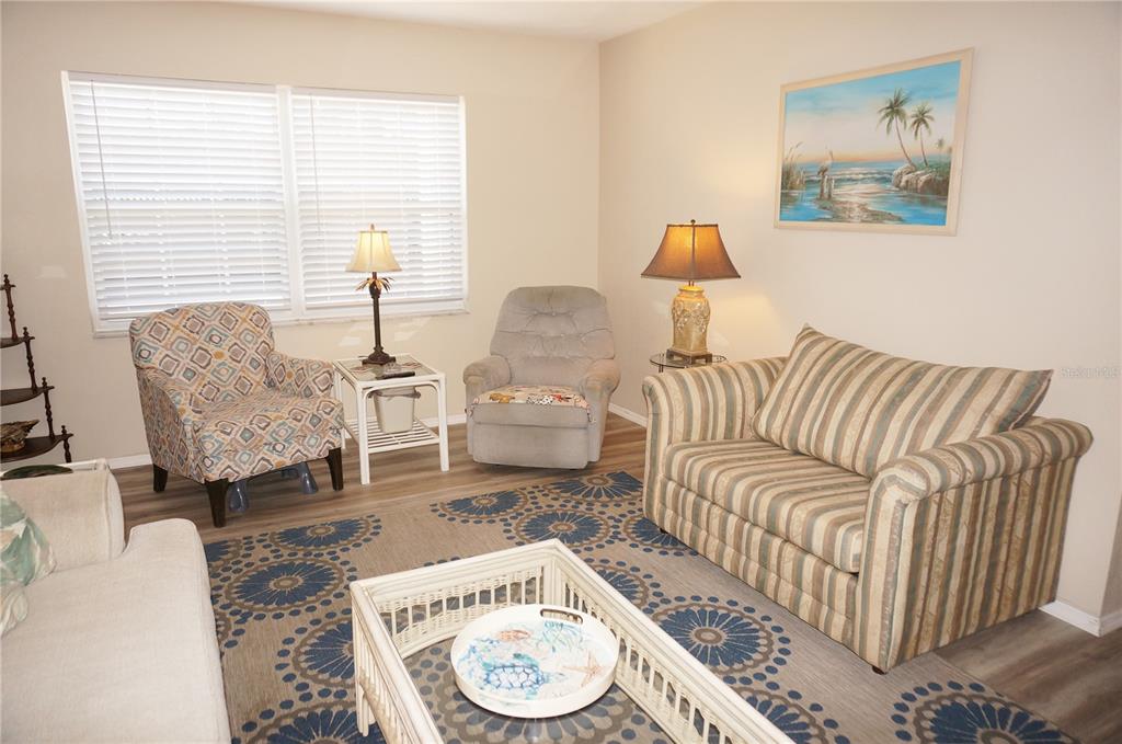 A living room features a patterned area rug, a striped loveseat, and two accent chairs — 4158 TAMIAMI TRAIL UNIT P1, PORT CHARLOTTE, FL
