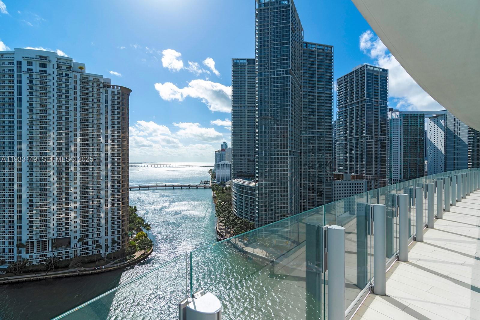 A high-rise balcony overlooks a river, a bridge, and surrounding city skyscrapers — 300 Biscayne Blvd Way # 1901, Miami FL 33131, MIAMI, FL