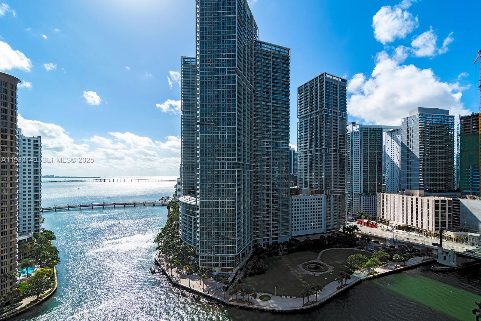 An aerial view shows high-rise apartment buildings situated along a waterfront park and bridge — 300 Biscayne Blvd Way # 1901, Miami FL 33131, MIAMI, FL