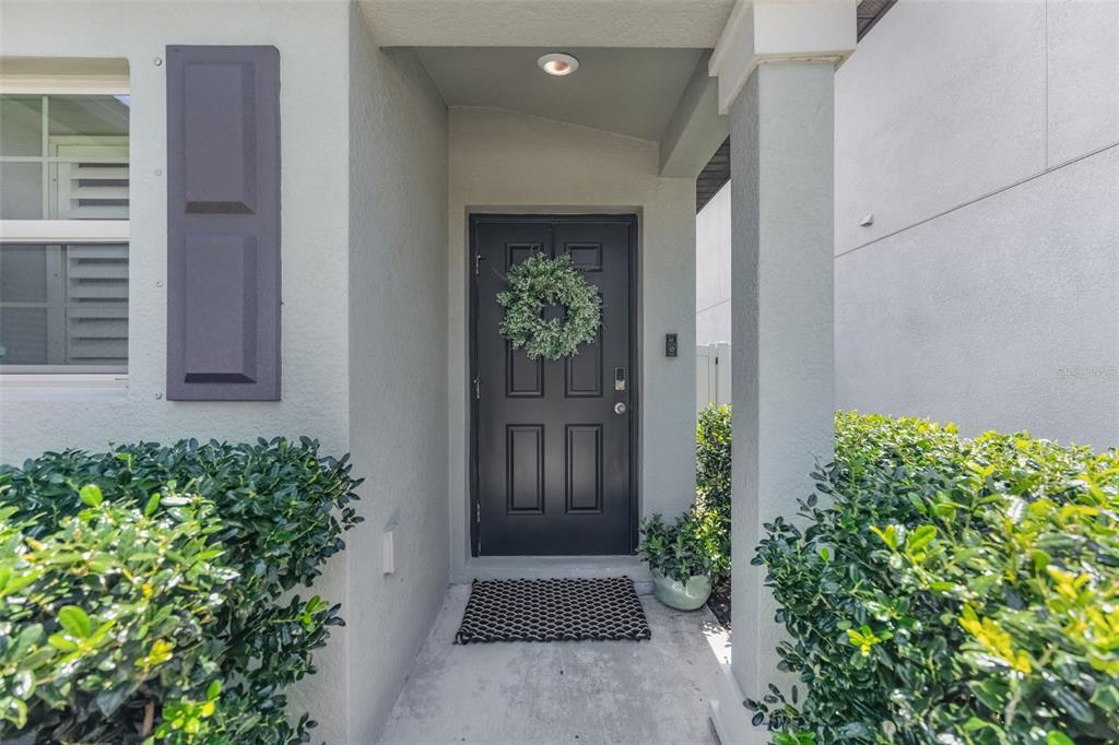 A hallway features a sliding barn door, a wooden bench, and light wood-look flooring — 7235 SALT RIVER AVENUE, SUN CITY CENTER, FL