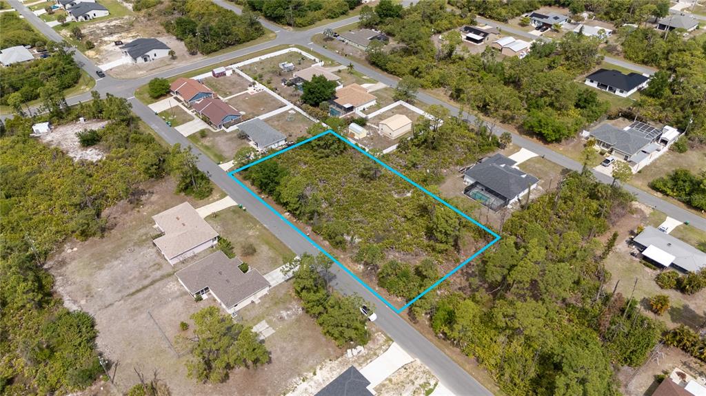An aerial view shows a vacant, wooded residential lot outlined in blue along a street — 11306 KIMBERLY AVENUE, ENGLEWOOD, FL