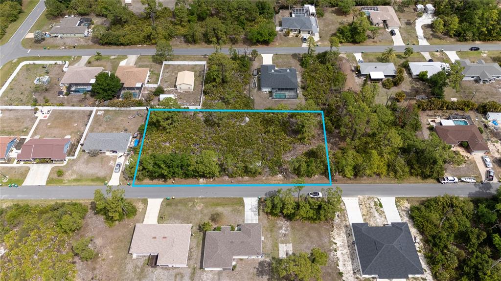 An aerial view shows a vacant, wooded residential lot outlined in blue along a street — 11306 KIMBERLY AVENUE, ENGLEWOOD, FL