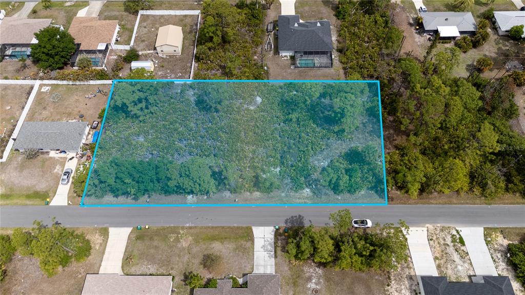 An aerial view shows a rectangular, wooded vacant lot highlighted in blue along a street — 11306 KIMBERLY AVENUE, ENGLEWOOD, FL