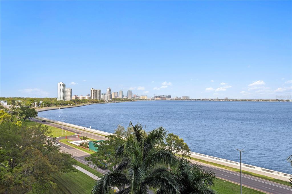 An elevated view of a waterfront road and a distant city skyline under blue skies — 3301 BAYSHORE BOULEVARD UNIT 806C, TAMPA, FL