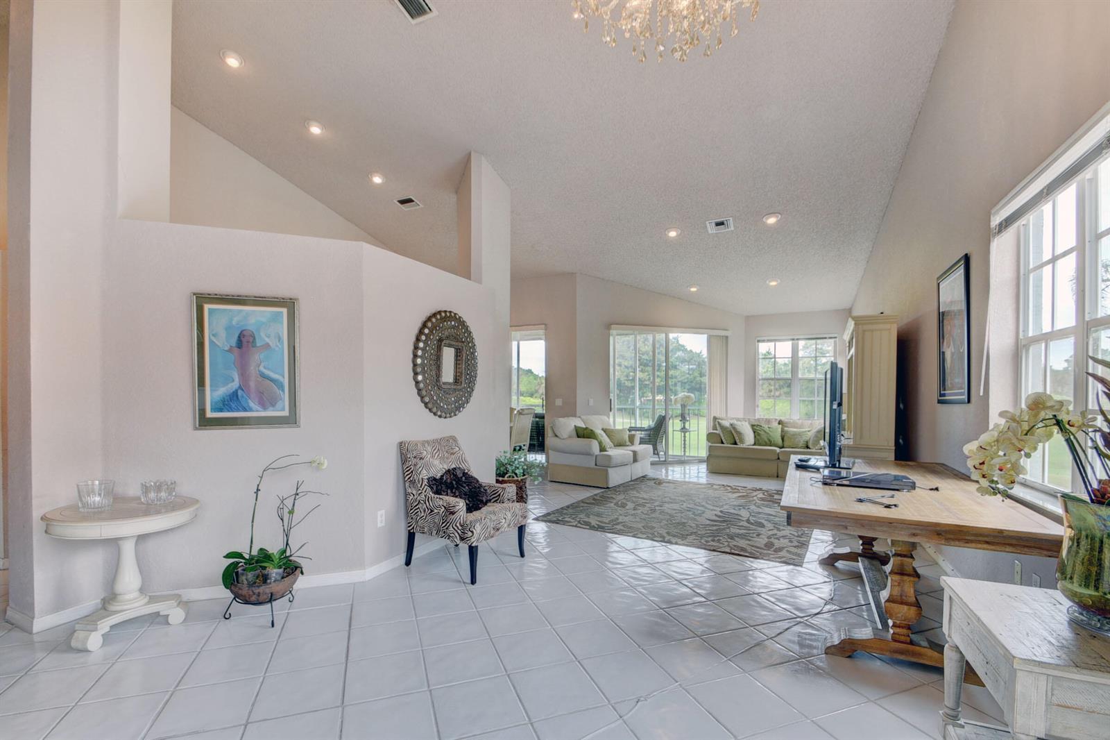 A spacious living room features white tile floors, vaulted ceilings, and a large wooden desk — 10220 Andover Coach Circle # H2, Lake Worth FL 33449, LAKE WORTH, FL
