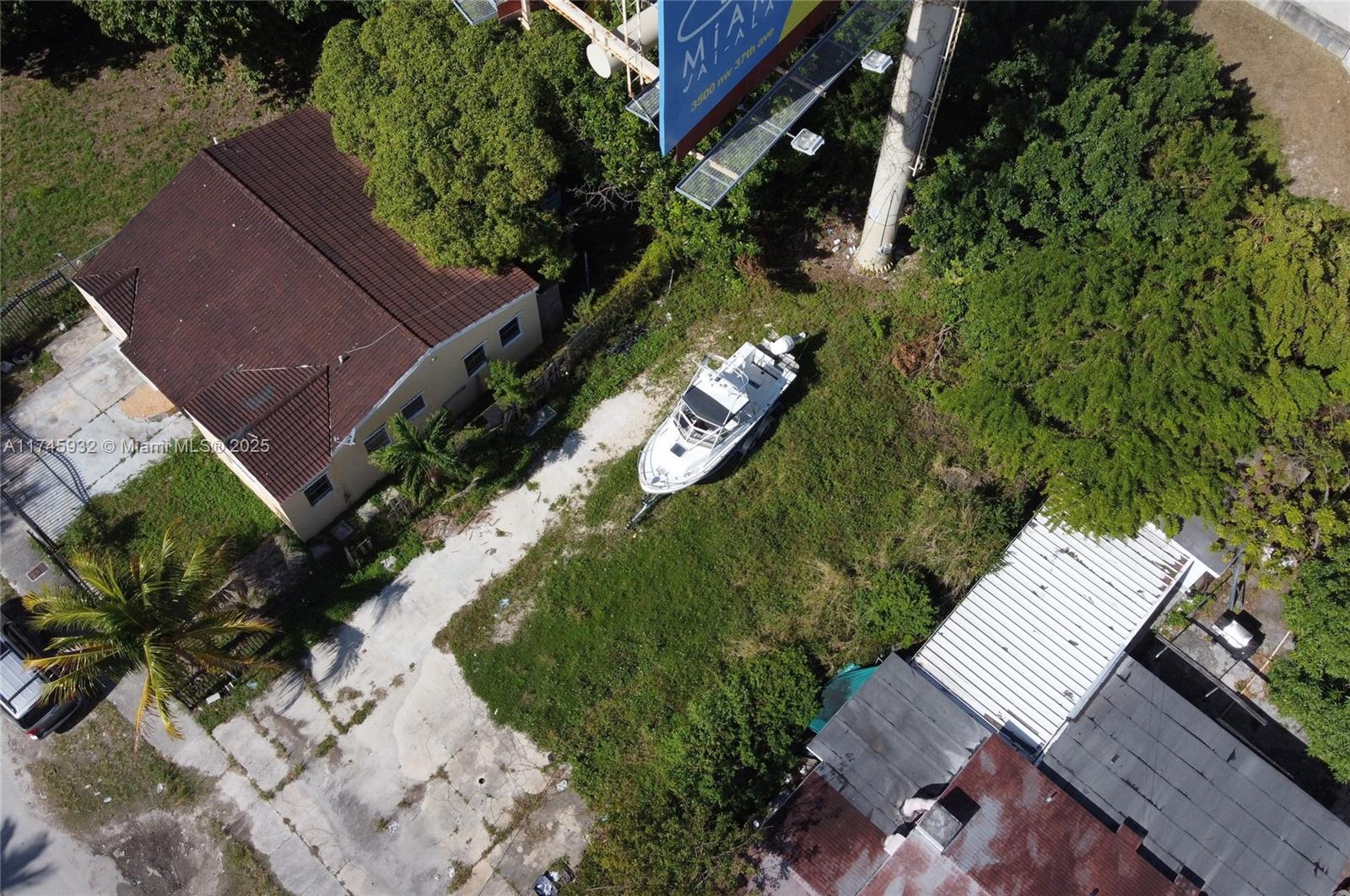 An aerial view shows a boat parked on a grassy lot between two buildings — 321 NW 37th St, Miami FL 33127, MIAMI, FL