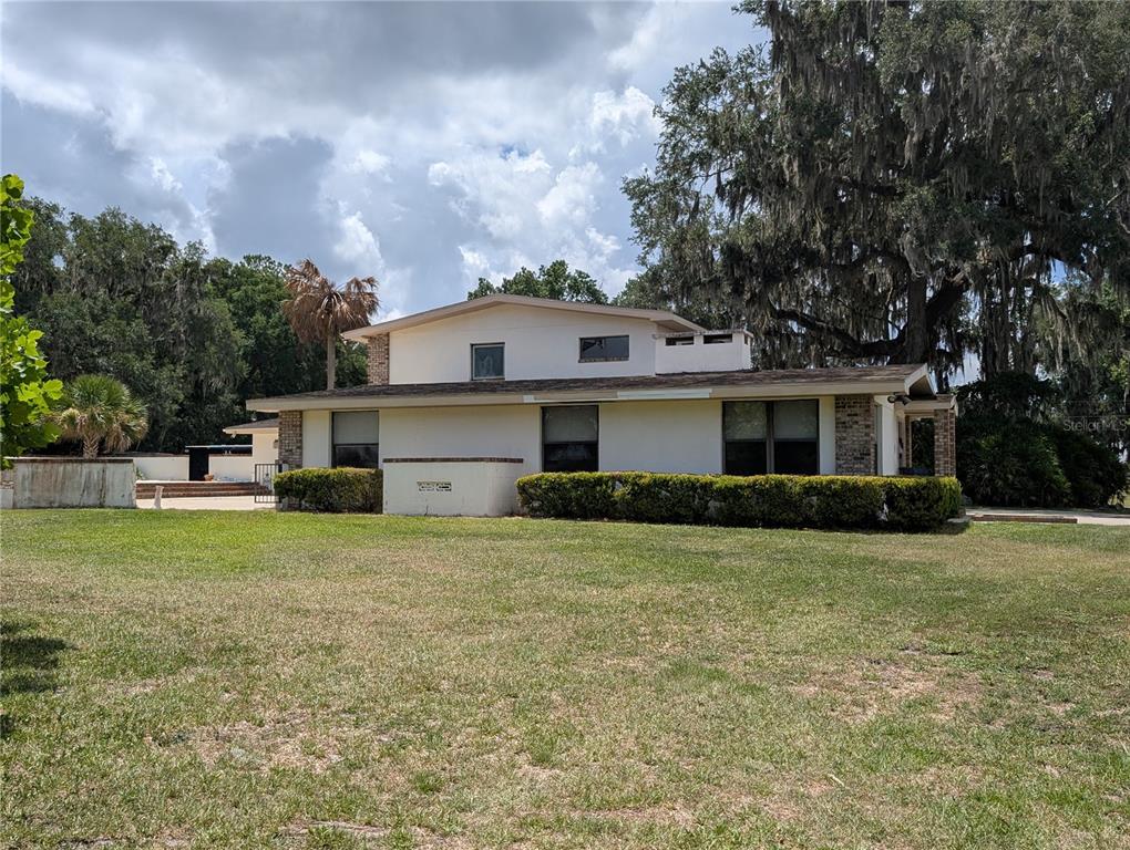 A two-story house with a white exterior, brick accents, and a large lawn — 1750 SE 80TH STREET, OCALA, FL