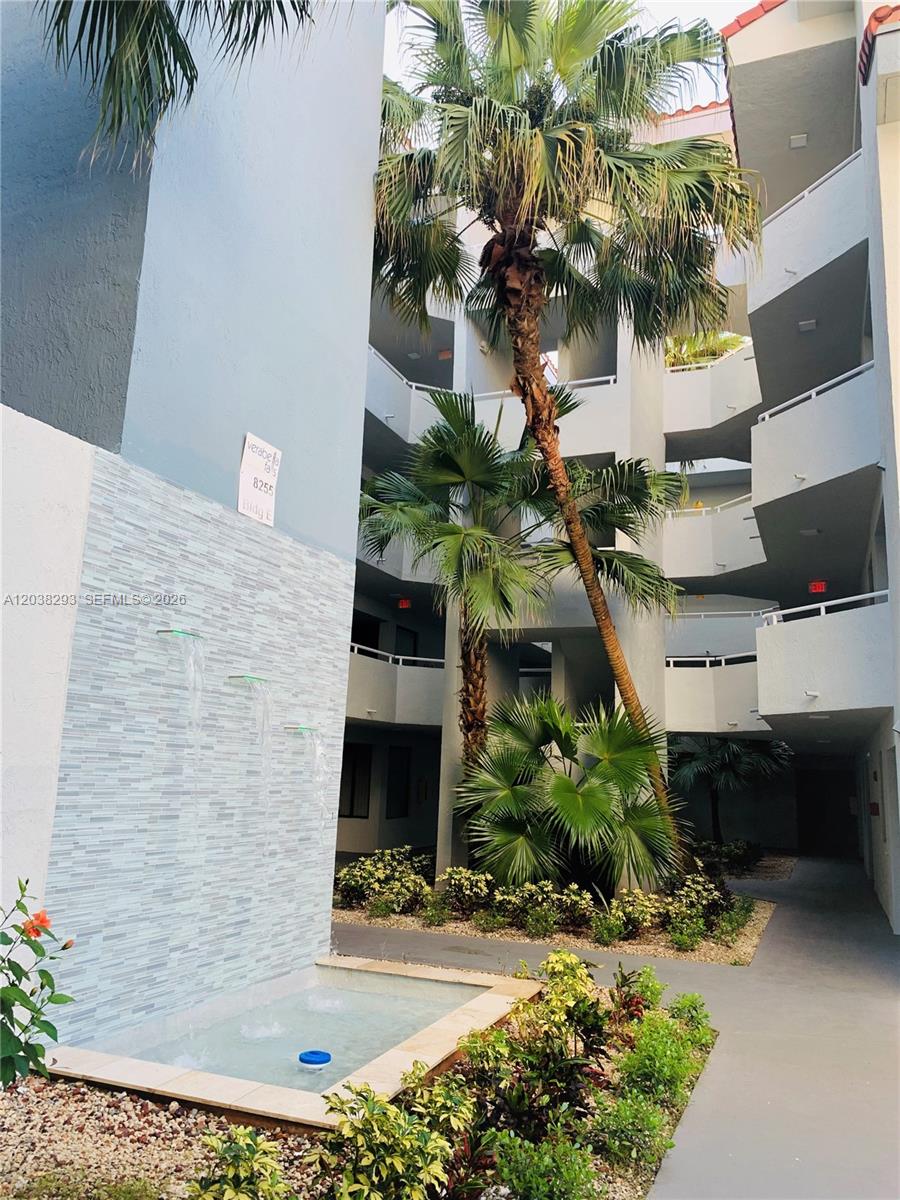 A multi-story apartment building courtyard features a tiered water fountain and several palm trees — 8255 SW 152nd Ave # 101, Miami FL 33193, MIAMI, FL