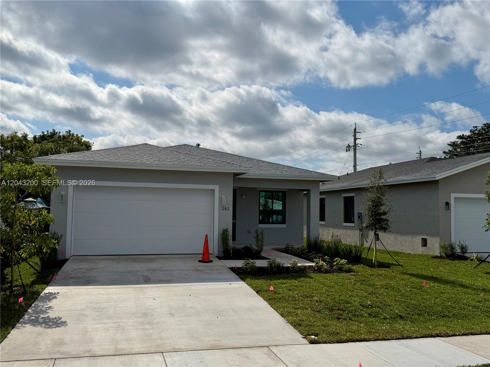 A single-story house with a gray exterior, a two-car garage, and a concrete driveway — 282 SW 2nd Ct, Deerfield Beach FL 33441, DEERFIELD BEACH, FL