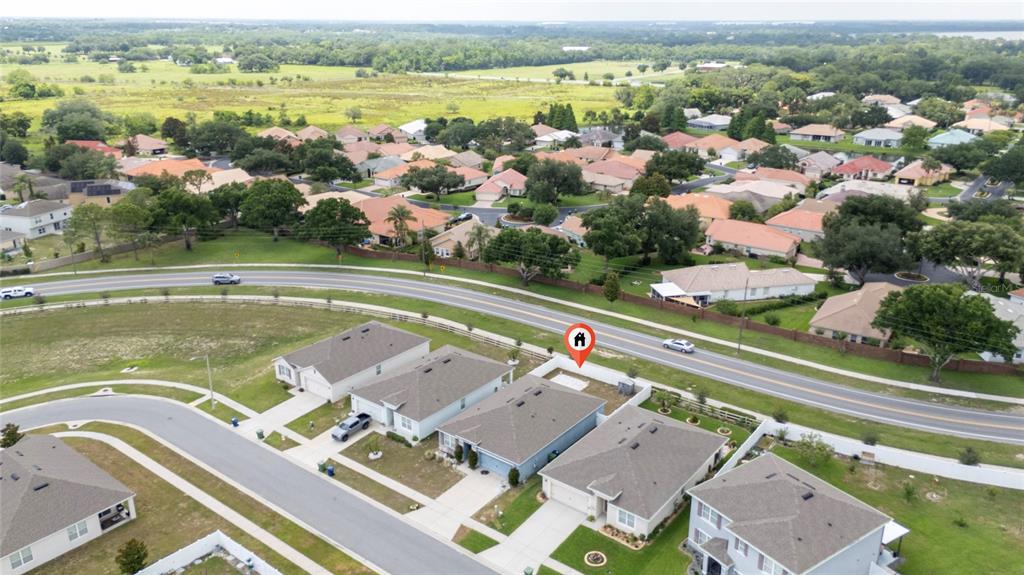 An aerial view shows a suburban neighborhood with houses, a road, and green space — 3268 COUNTRY WALK CLUB CIRCLE, WINTER HAVEN, FL