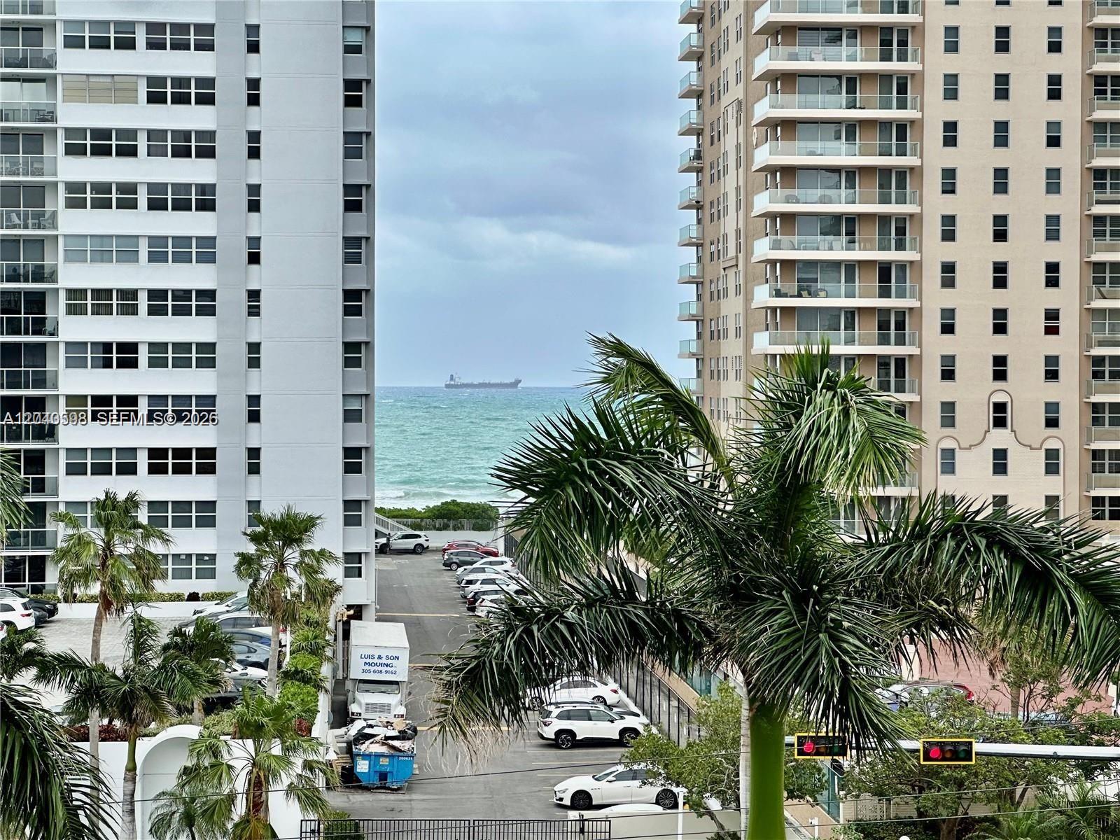 An exterior view shows a parking lot between two high-rise buildings overlooking the ocean — 1893 S Ocean Dr # 601, Hallandale Beach FL 33009, HALLANDALE BEACH, FL