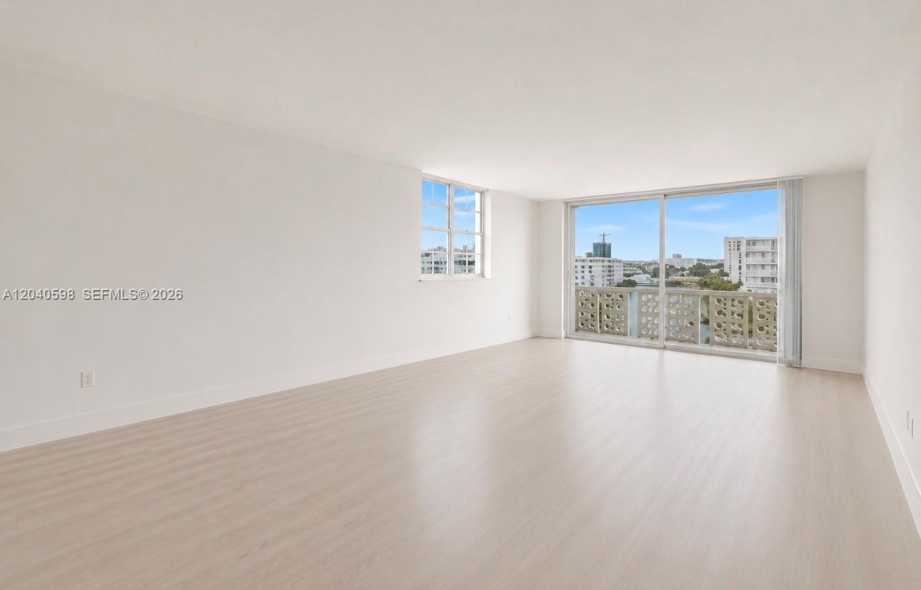 An empty room with light wood-look flooring, white walls, and a balcony with water views — 1893 S Ocean Dr # 601, Hallandale Beach FL 33009, HALLANDALE BEACH, FL