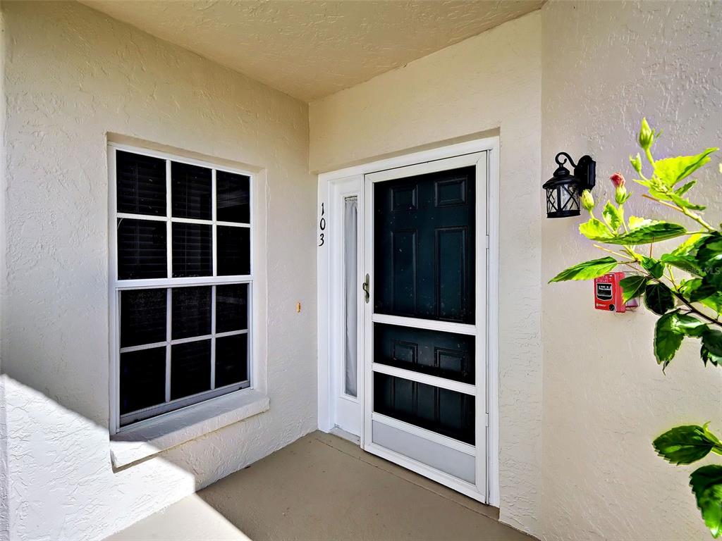 A front entryway features a white door with a screen, a window, and a light — 902 ADDINGTON COURT UNIT 103, VENICE, FL