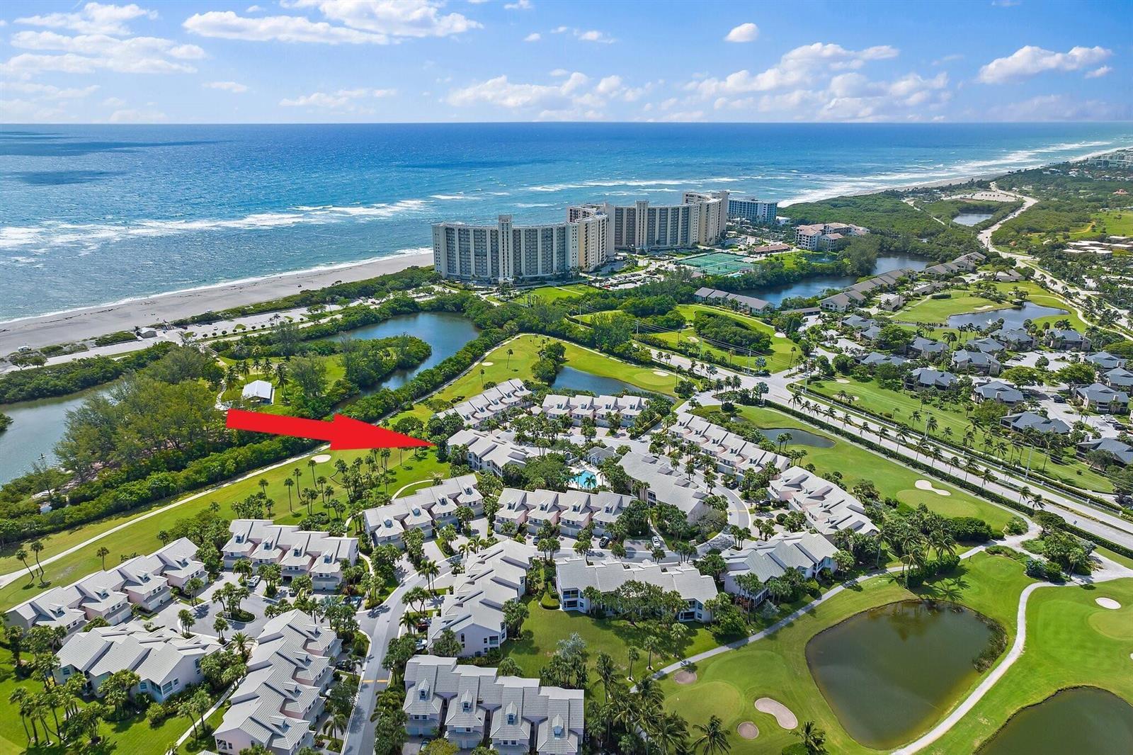 An aerial view shows a residential complex with white buildings near a golf course and ocean — 2905 Fairway Drive N, Jupiter FL 33477, JUPITER, FL