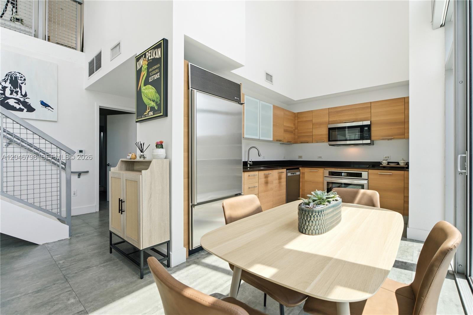 A modern kitchen features light wood cabinets, stainless steel appliances, and an adjacent dining area — 3301 NE 1st Ave, Miami FL 33137, MIAMI, FL