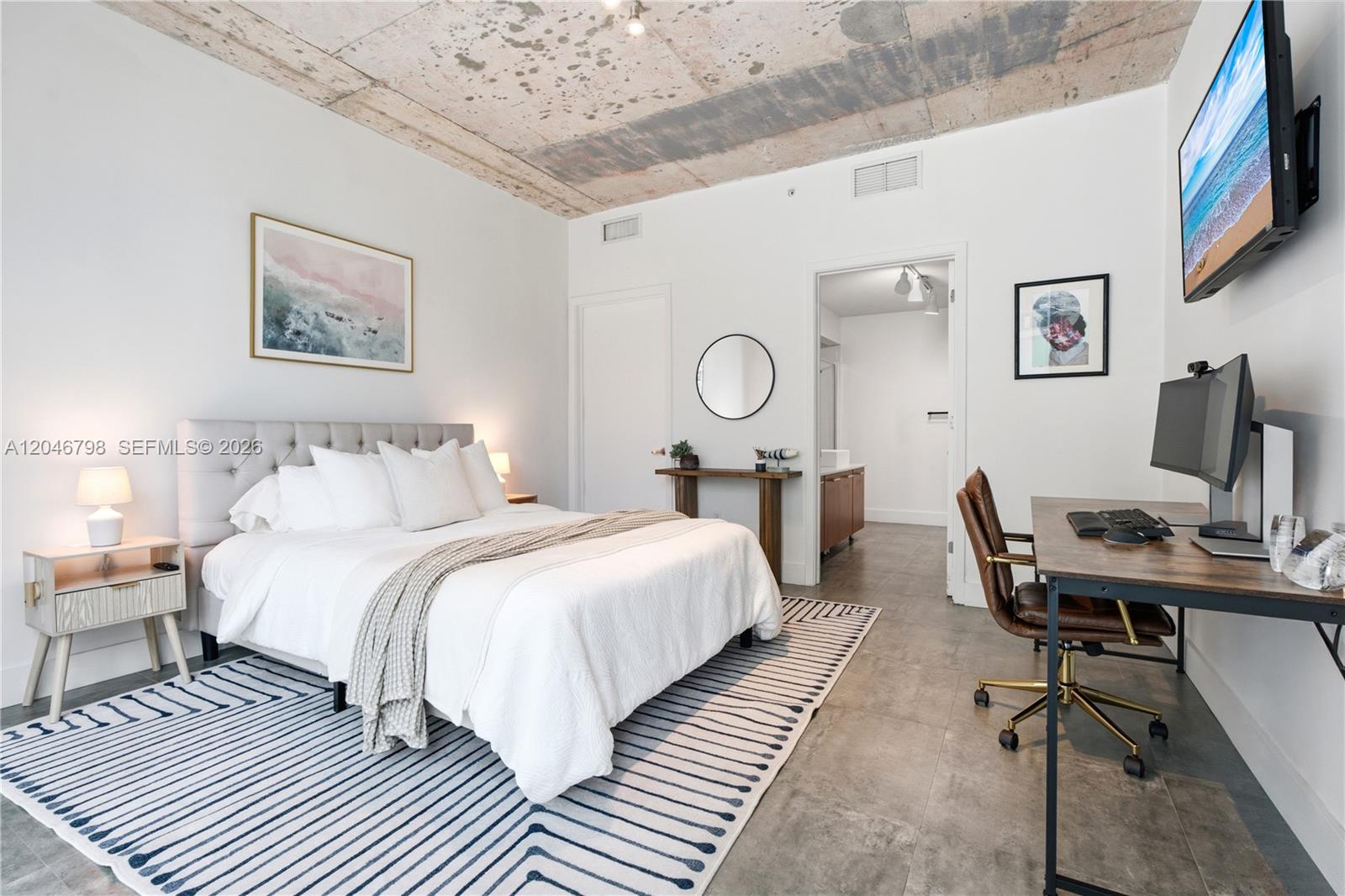 A bedroom features a bed, desk, and exposed concrete ceiling with tile flooring — 3301 NE 1st Ave, Miami FL 33137, MIAMI, FL