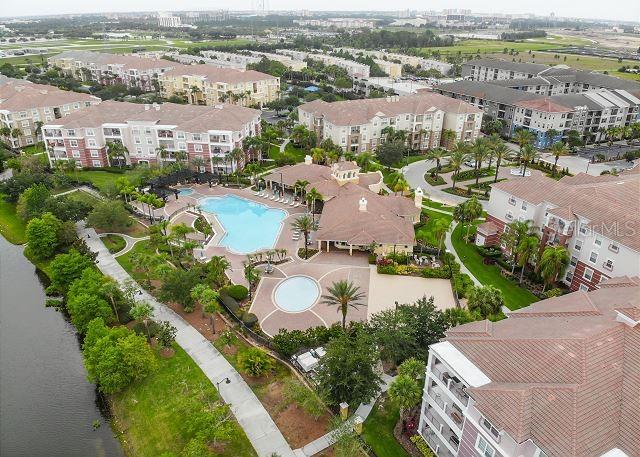 An aerial view shows apartment buildings surrounding a central swimming pool and clubhouse area — 4862 CAYVIEW AVENUE UNIT 20909, ORLANDO, FL