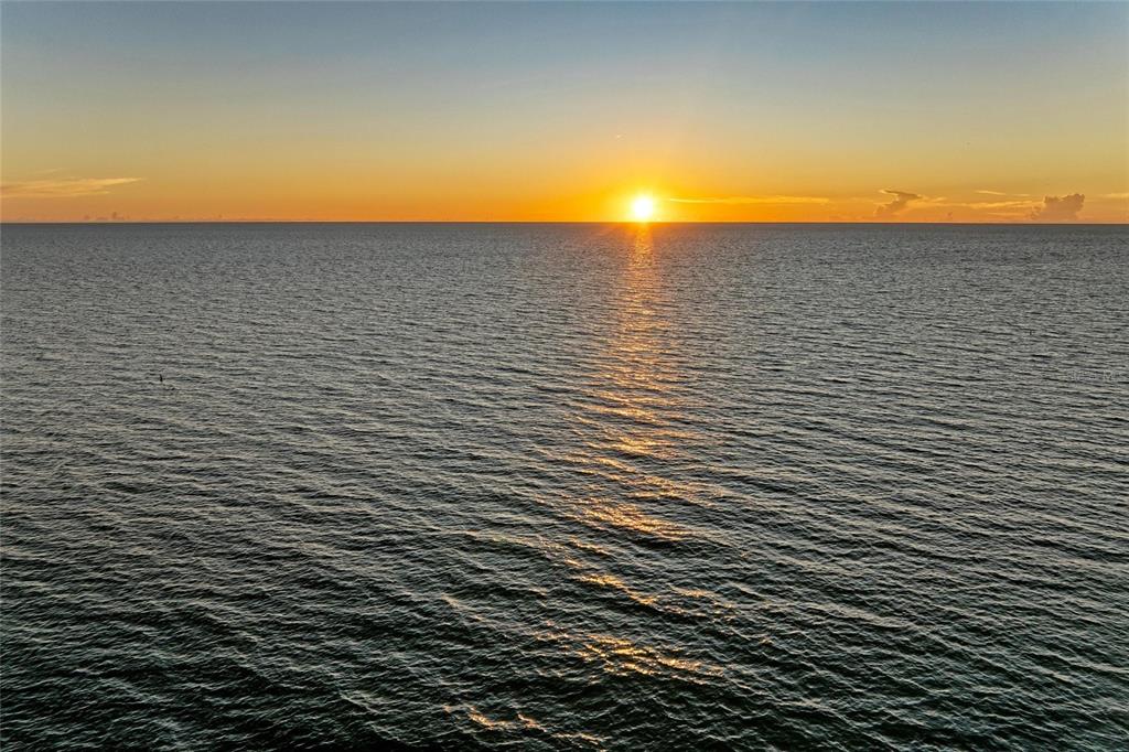 A sunset view over the ocean with a clear horizon line — 7110 MANASOTA KEY ROAD, ENGLEWOOD, FL