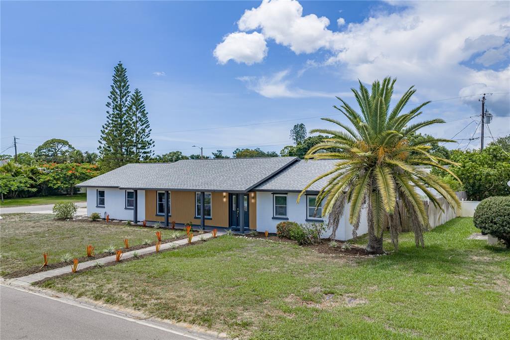 A single-story house with a gray roof, white and wood siding, and a large palm tree — 3810 18TH AVENUE W, BRADENTON, FL