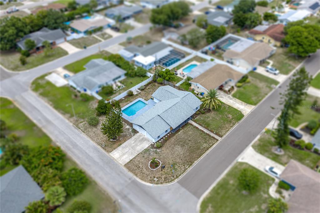 A backyard features a rectangular swimming pool with a gray concrete deck and white fencing — 3810 18TH AVENUE W, BRADENTON, FL
