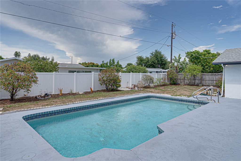 The exterior of a single-story house features a covered porch, vertical wood-look siding, and white brick — 3810 18TH AVENUE W, BRADENTON, FL