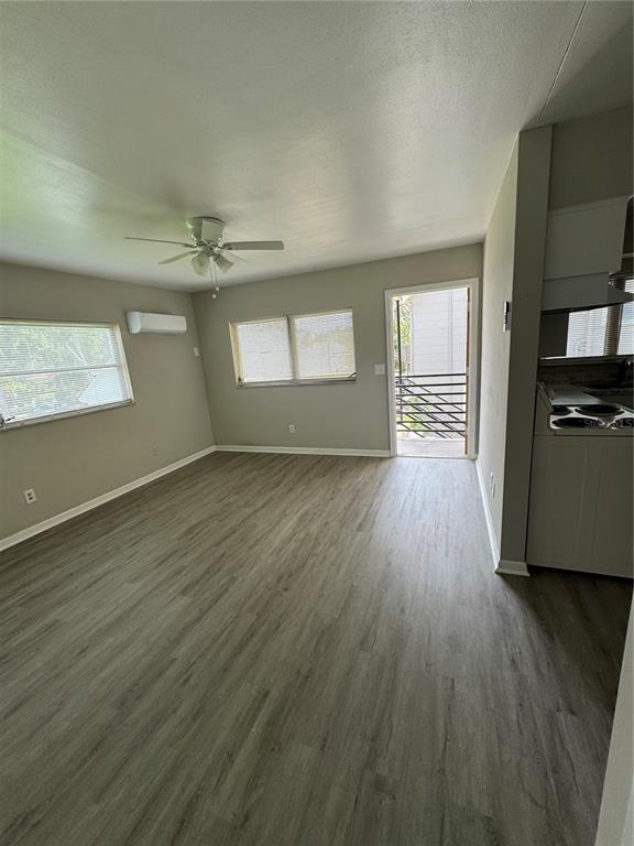 An open living area features light wood-look flooring, a ceiling fan, and a balcony door — 615 OAK AVENUE, CLEARWATER, FL