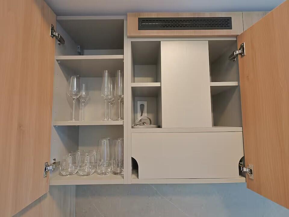 Open kitchen cabinets with light wood doors, glass shelves, and organized glassware — 121 NE 5th Street, Miami FL 33132, MIAMI, FL