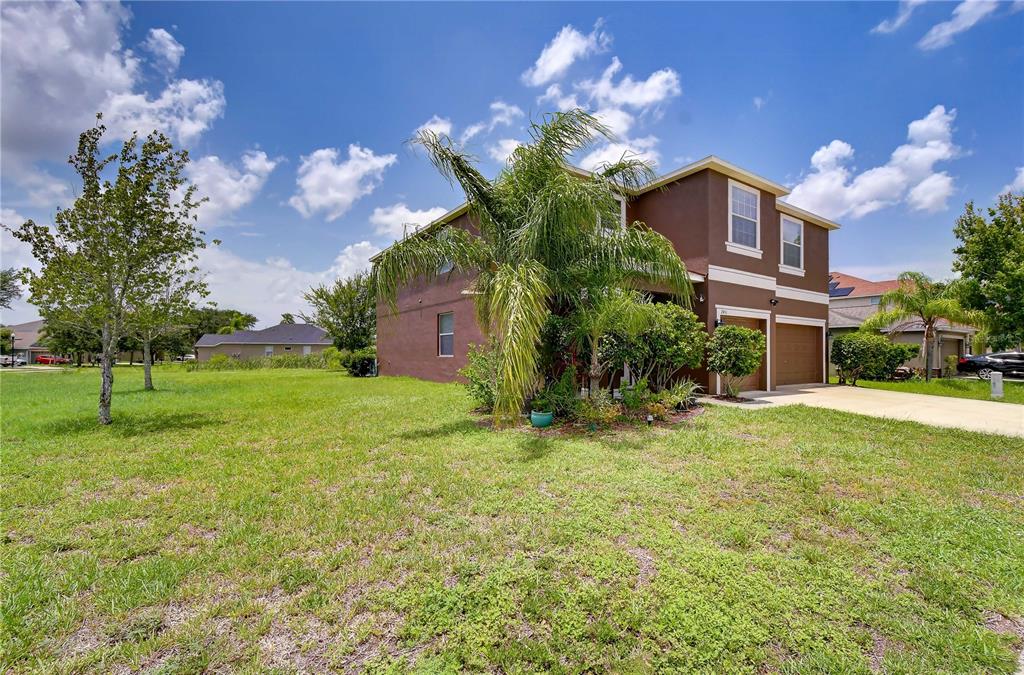 A kitchen features dark wood cabinets, granite countertops, stainless steel appliances, and a central island — 2451 DAKOTA ROCK DRIVE, RUSKIN, FL
