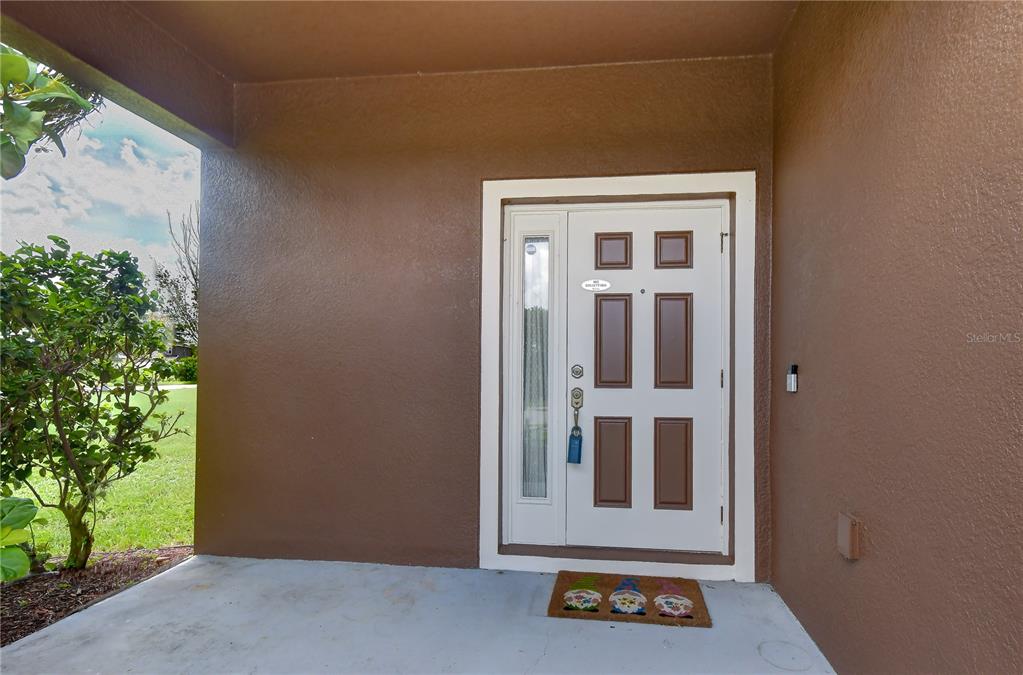 The exterior of a two-story house features a brown facade, a front door, and two garages — 2451 DAKOTA ROCK DRIVE, RUSKIN, FL