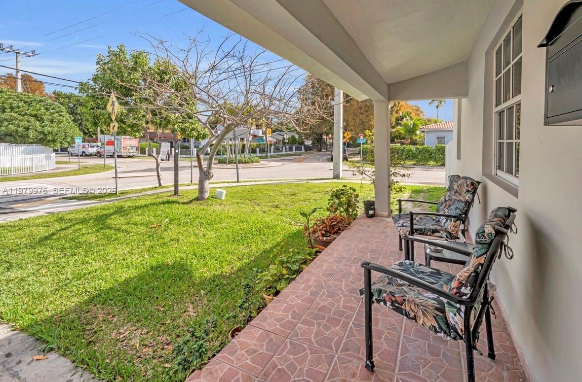 A covered porch features tiled flooring, two chairs, and a view of a residential street — 2900 SW 19th St, Miami FL 33145, MIAMI, FL