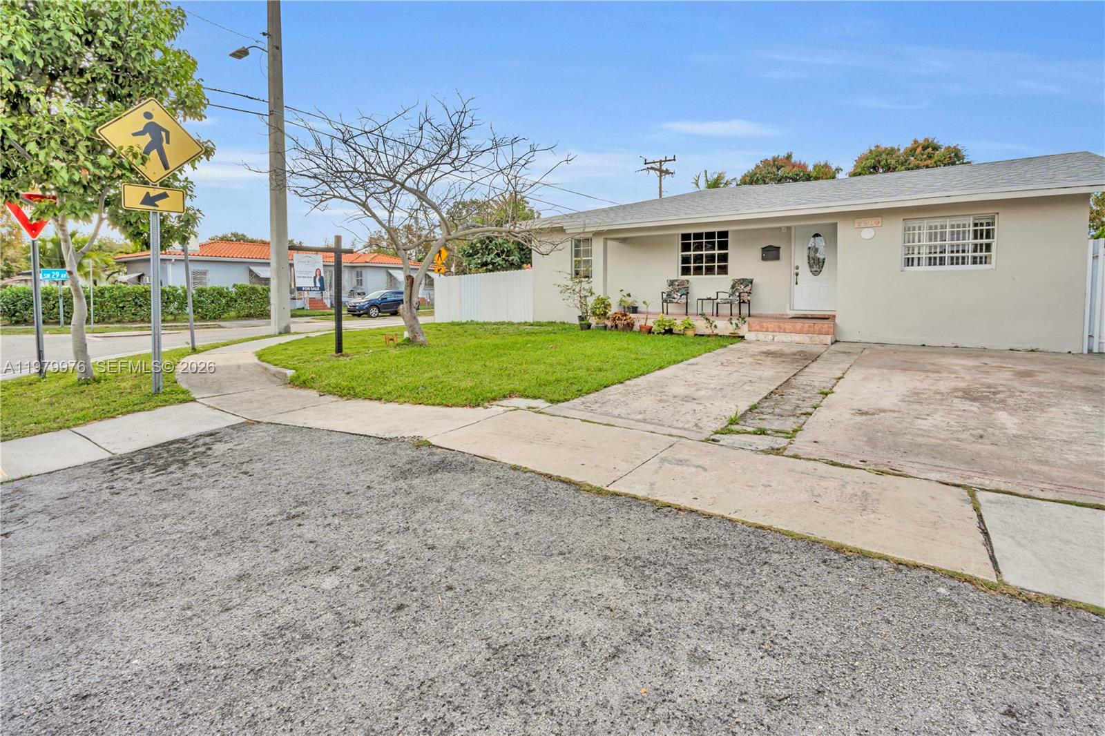 A single-story house with a white exterior, a concrete driveway, and a front lawn — 2900 SW 19th St, Miami FL 33145, MIAMI, FL