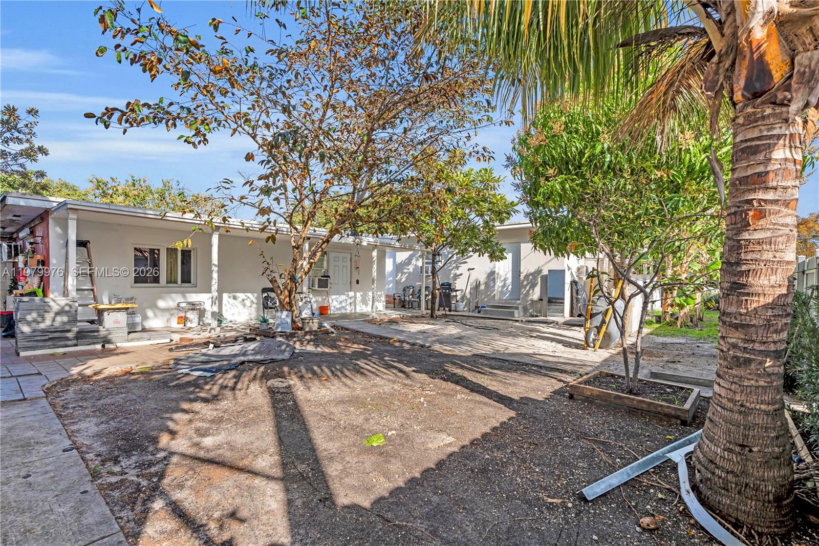 A backyard area features a paved patio, a large tree, and a single-story house exterior — 2900 SW 19th St, Miami FL 33145, MIAMI, FL