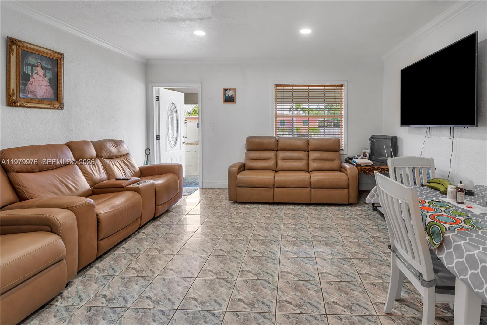 A living room features tan leather sofas, tile flooring, a wall-mounted television, and a dining area — 2900 SW 19th St, Miami FL 33145, MIAMI, FL