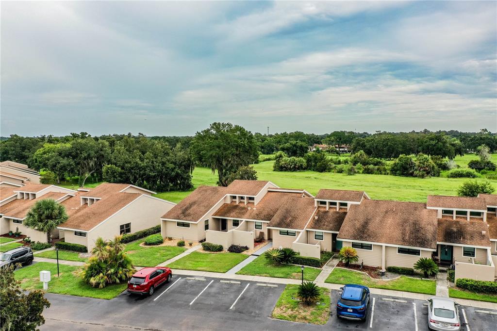 An aerial view shows a row of tan townhouses with brown roofs and parking spaces — 5225 IMPERIAL LAKES BOULEVARD UNIT 22, MULBERRY, FL