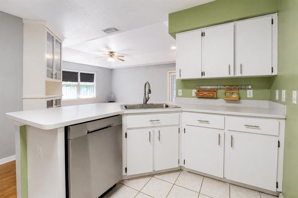 A backyard with a grassy lawn, mature trees, and a house with a screened-in porch — 2523 NW 38 PLACE, GAINESVILLE, FL