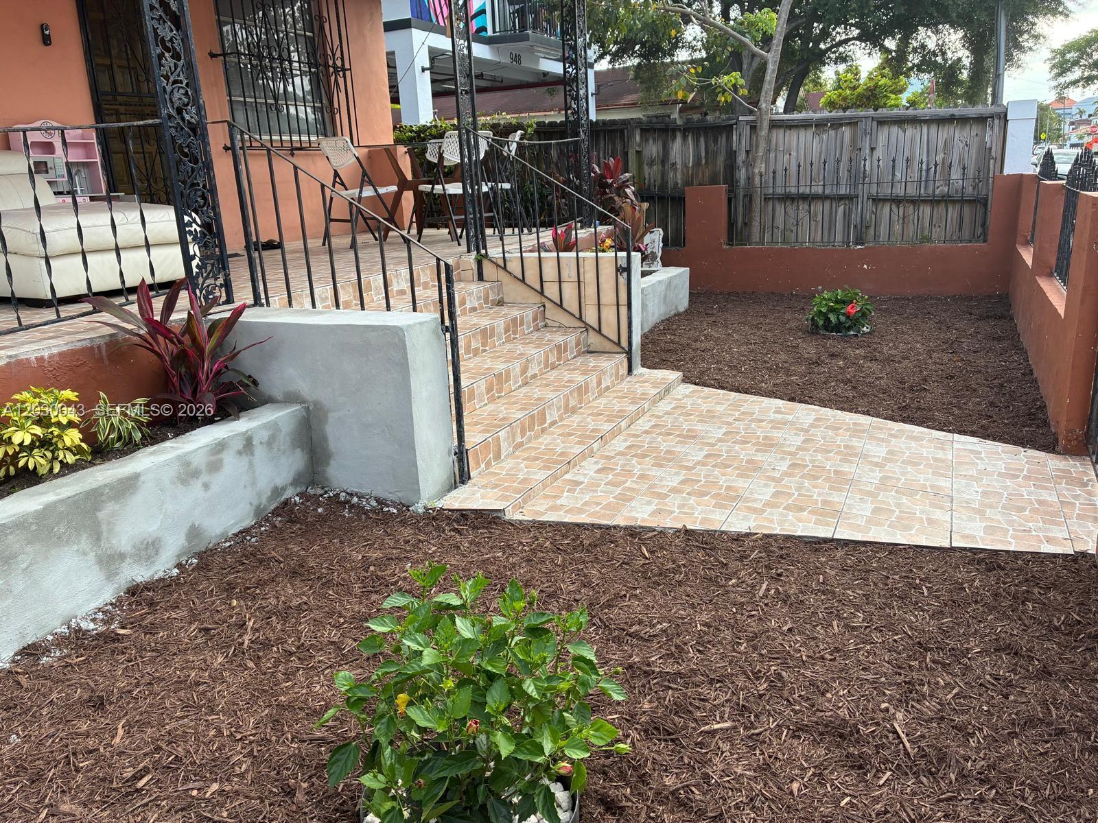 A tiled walkway leads to concrete steps and a porch with a white sofa — 934 SW 3rd St, Miami FL 33130, MIAMI, FL
