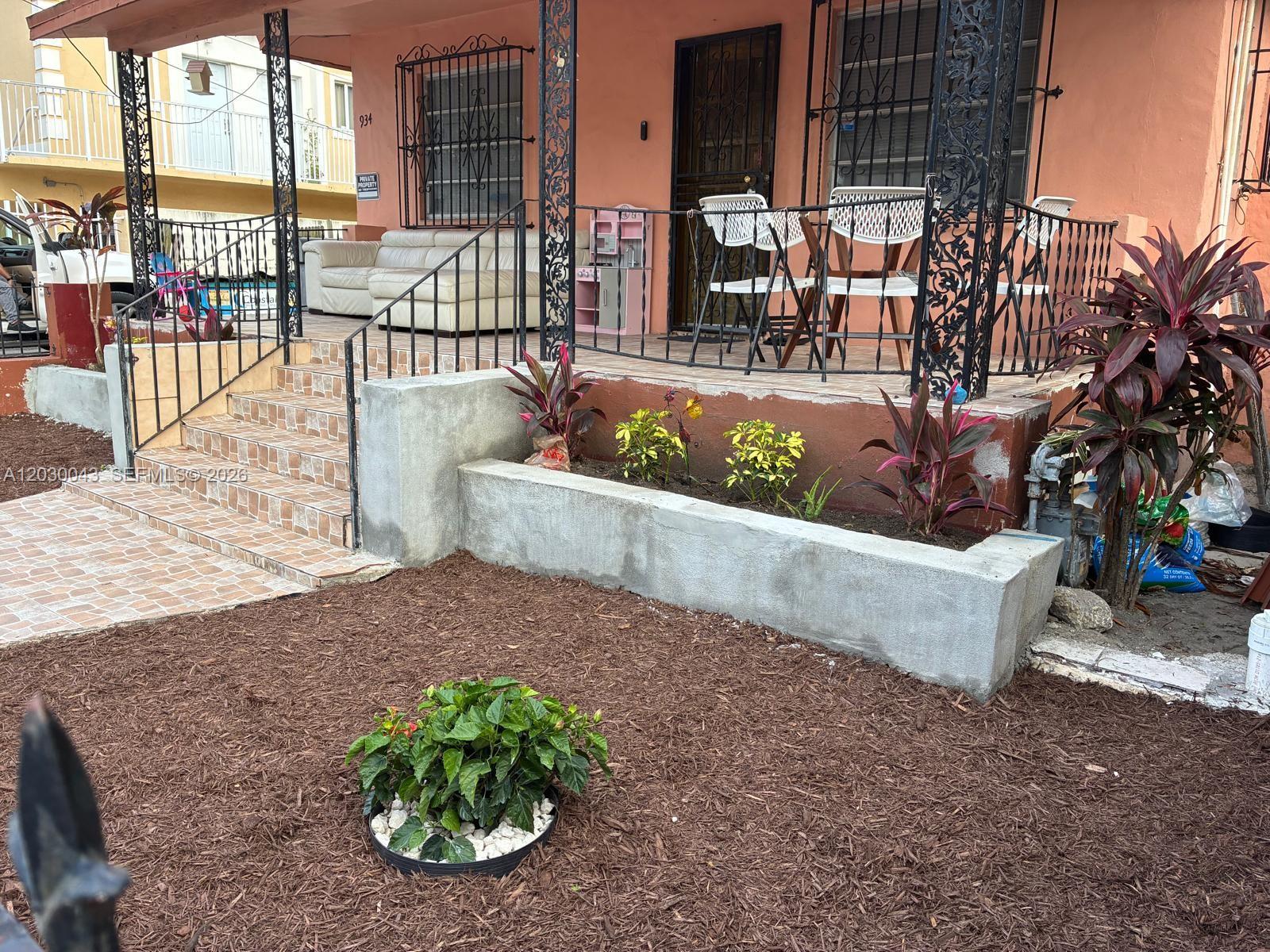 A front porch with a concrete planter, tiled stairs, and metal railings on a house — 934 SW 3rd St, Miami FL 33130, MIAMI, FL