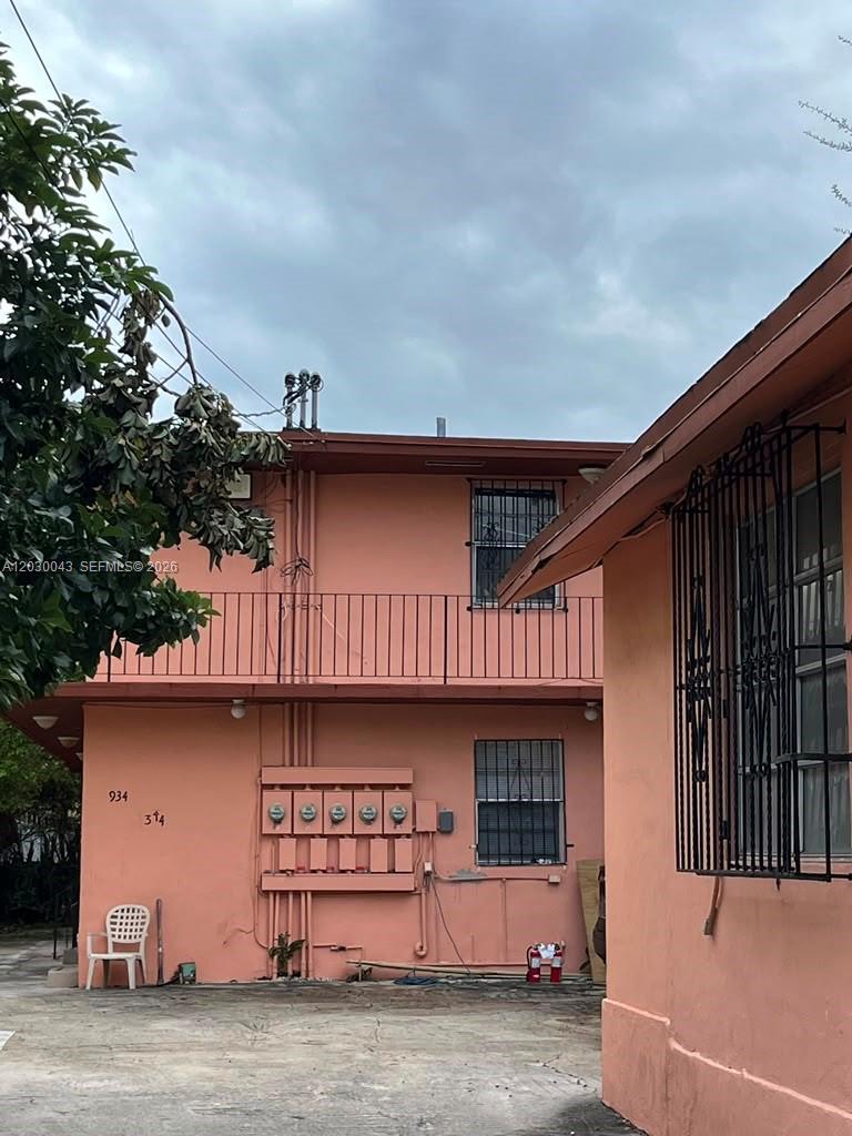 A two-story peach-colored apartment building exterior with a metal balcony and utility meters — 934 SW 3rd St, Miami FL 33130, MIAMI, FL