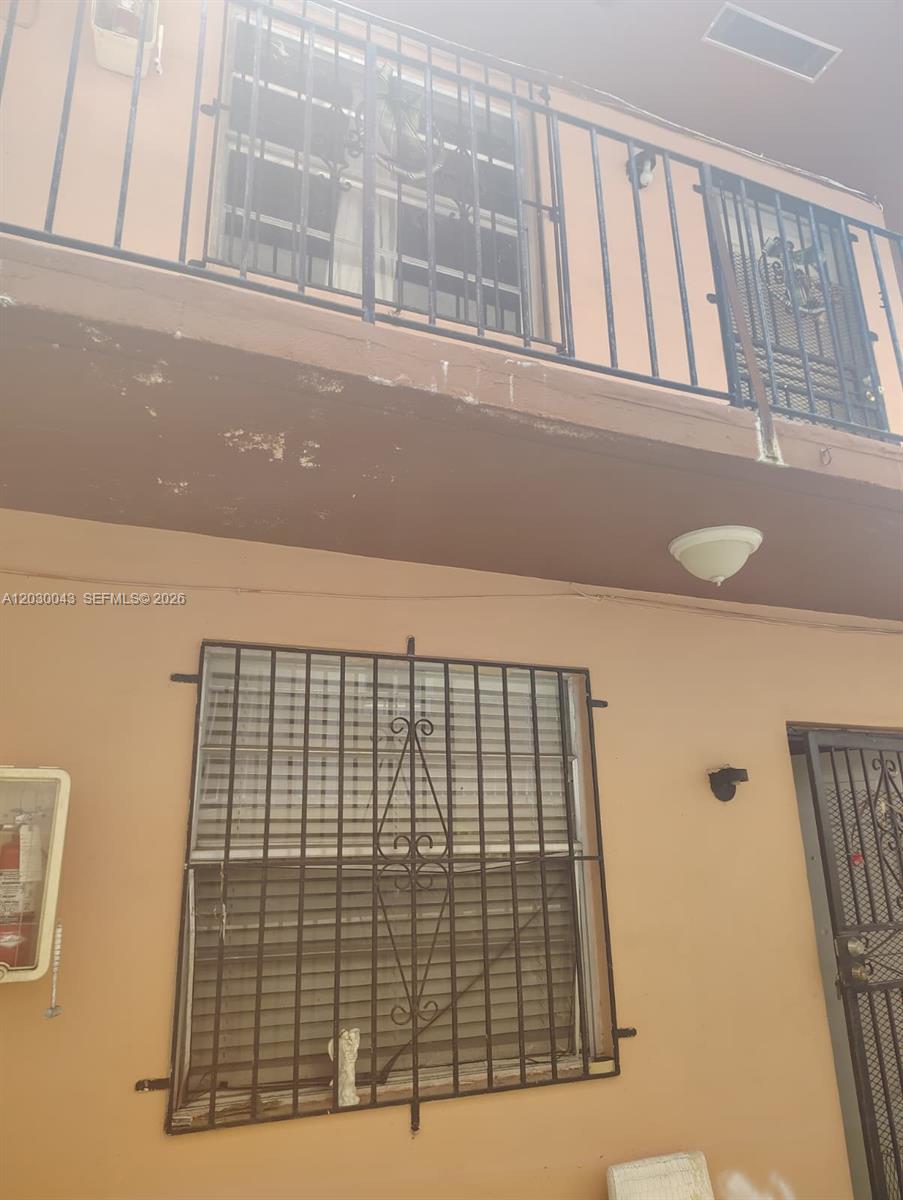 The exterior of a two-story building features metal security bars on the windows and balcony — 934 SW 3rd St, Miami FL 33130, MIAMI, FL